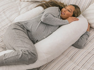 pregnant woman in bed with the therapeutic body pillow