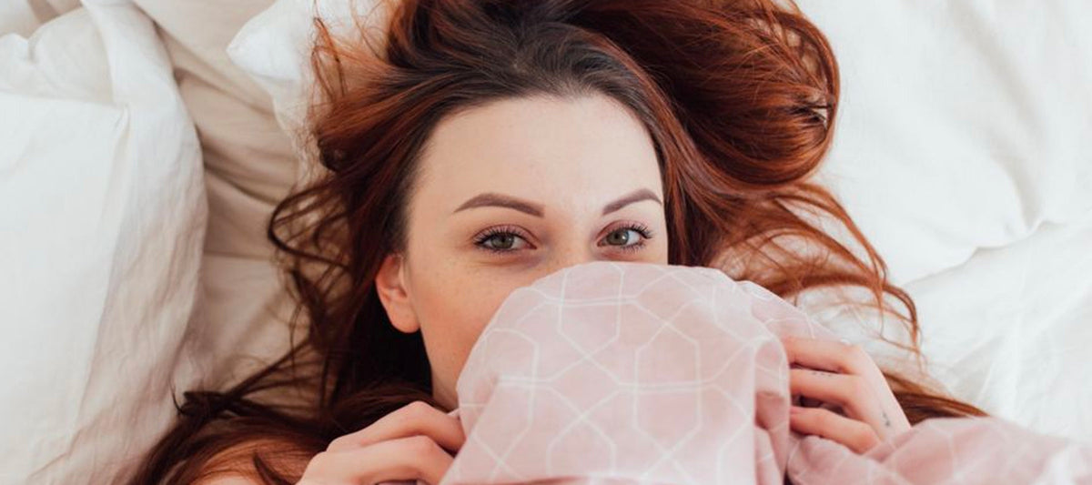 Woman sleeping under bed sheets