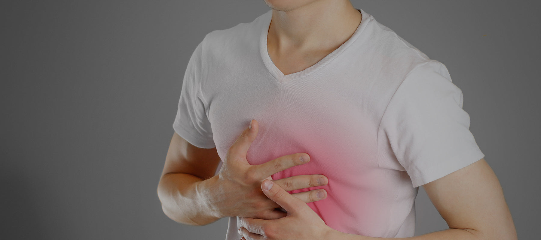 man holding chest from heartburn