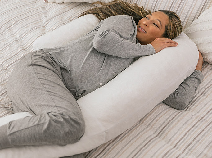 pregnant woman in bed with the therapeutic body pillow
