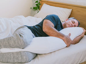 men sleeping in bed with the therapeutic body pillow